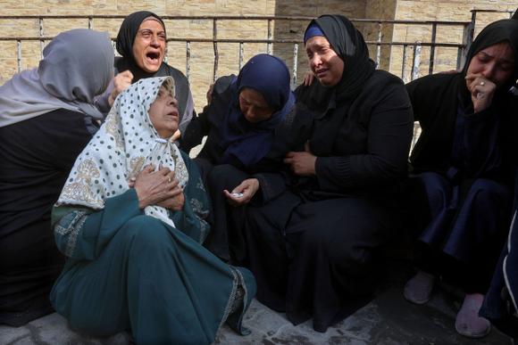 Femmes palestiniennes en deuil à la suite d’une attaque aérienne israélienne, à l’hôpital Al-Ahli, à Gaza, le 20 mai 2025.