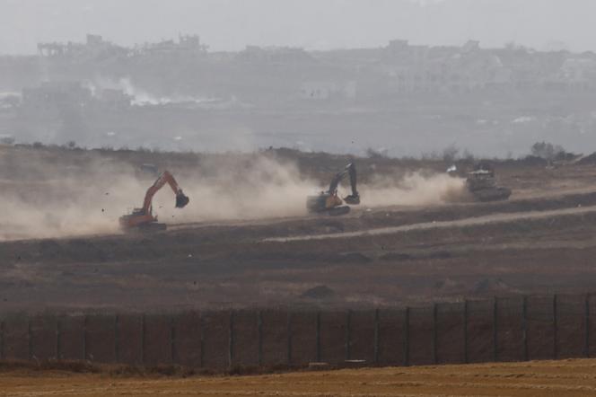 Un véhicule militaire israélien et des excavateurs manœuvrent à l’intérieur de la bande de Gaza, vu d’Israël, 18 mai 2025.