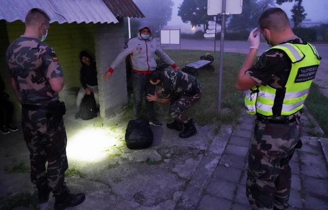 Des gardes-frontières lituaniens arrêtent des migrants à la frontière entre la Lituanie et la Biélorussie à Kalviai, en Lituanie, 7 juillet 2021.