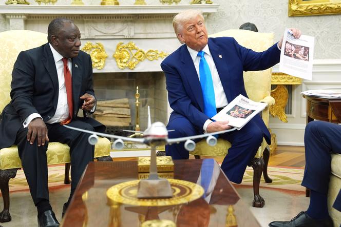 Le président américain Donald Trump présente des documents lors de sa rencontre avec le président sud-africain Cyril Ramaphosa, dans le bureau ovale de la Maison Blanche, à Washington, le 21 mai 2025.