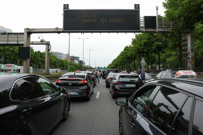 A Saint-Denis (Seine-Saint-Denis), des chauffeurs de taxi ralentissent la circulation sur l’A1 menant à Paris, le 21 mai 2025.