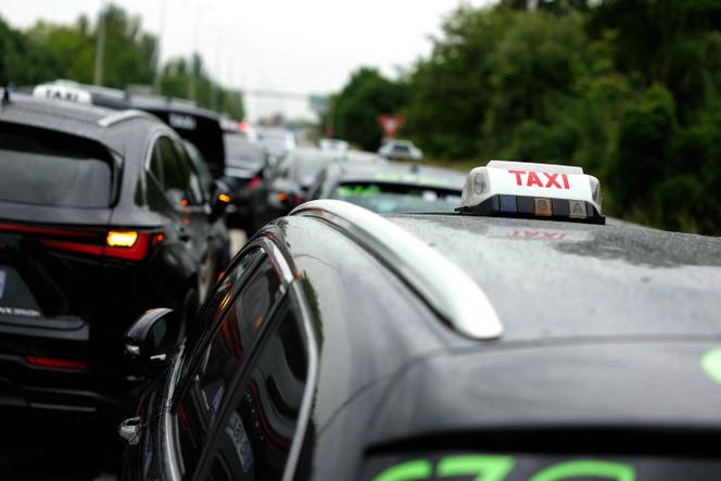 Des chauffeurs de taxi bloquent l’autoroute A1 afin de protester contre la concurrence des voitures privées avec chauffeur et contre des changements proposés dans le financement des services de transport médical, à La Courneuve (Seine-Saint-Denis), le 21 mai 2025.