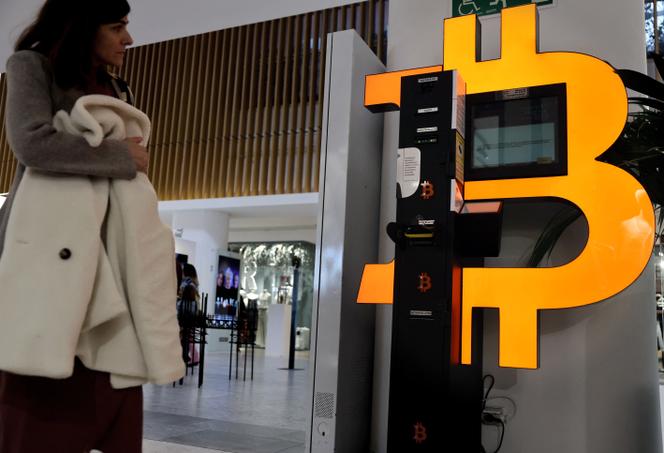 Devant un distributeur automatique de Bitcoin, dans un centre commercial de Madrid, le 7 mars 2025.