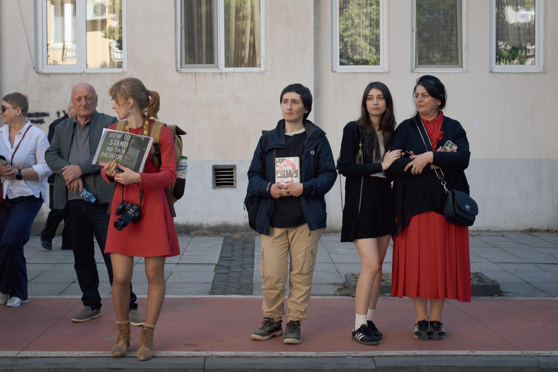 Des habitants, des journalistes et des proches de Mzia Amaghlobeli attendent la sortie du fourgon qui ramène la reporter dans sa cellule, à Batoumi, en Géorgie, le 16 mai 2025.