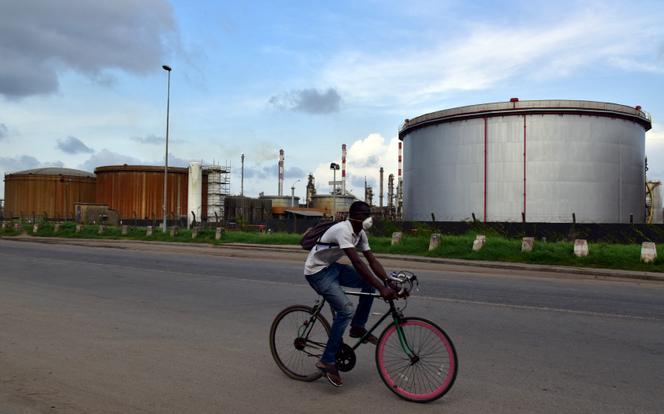 Un homme circule à vélo près des installations de la Société ivoirienne de raffinage, le 16 novembre 2016, à Abidjan.