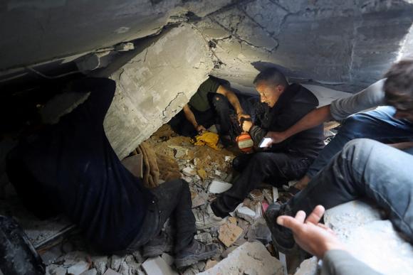 Des Palestiniens cherchent des victimes dans les décombres après une frappe israélienne sur une maison à Jabaliya, dans le nord de la bande de Gaza, le 23 mai 2025.