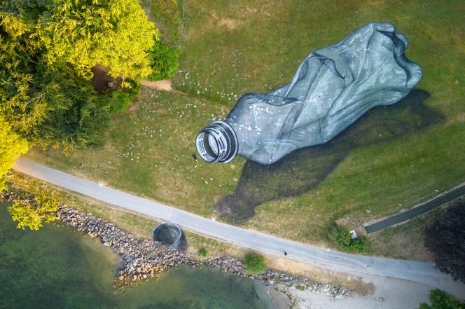 Peinture en trompe-l’oeil (à la craie et au charbon) sur l’herbe du parc Bourget, dans le cadre du projet « Trash » de l’artiste franco-suisse Saype, à Lausanne, en Suisse, le 16 juin 2023.

