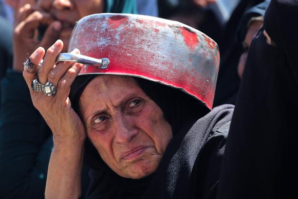 Une Palestinienne attend de recevoir un repas chaud, à un point de distribution du camp de réfugiés de Nousseirat. A Gaza, le 24 mai 2025.