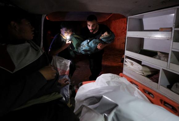 Des médecins transportent le corps d’un palestinien tué lors de frappes israéliennes sur l’école Fahmi Aljarjaoui qui abritait des déplacés, dans la ville de Gaza, le 26 mai 2025.