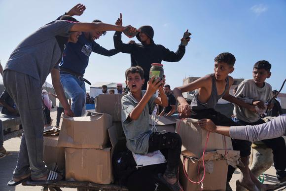 Des déplacés palestiniens ouvrent les colis d’aide alimentaire distribués à Rafah, dans le sud de la bande de Gaza, le 27 mai 2025.