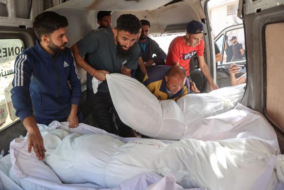 Des personnes déchargent les corps de personnes tuées lors d’une frappe israélienne, à l’hôpital Al-Shifa, dans la bande de Gaza, le 26 mai 2025.