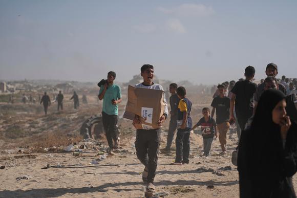 Un Palestinien transporte un colis d’aide alimentaire distribué par la Fondation humanitaire de Gaza, une organisation soutenue par les Etats-Unis et approuvée par Israël, à Rafah, dans le sud de la bande de Gaza, le mardi 27 mai 2025.