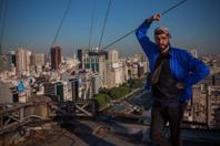 Image 68: Tho Clerc, street-artiste et peintre franais, sur le toit de lAvenida 9 de Julio, Buenos Aires, en 2024.