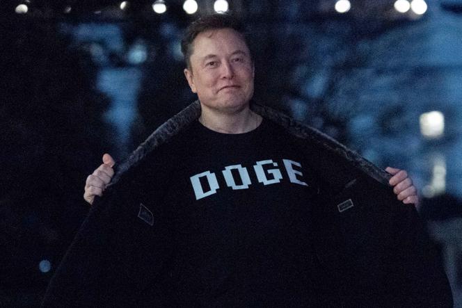 Elon Musk mostra sua camiseta com os dizeres “DOGE” enquanto caminha pela Casa Branca em 9 de março de 2025.