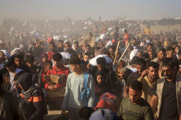 Des Palestiniens portent des cartons et des sacs contenant de la nourriture fournie par la Gaza Humanitarian Foundation, à Rafah, dans le sud de la bande de Gaza, le 29 mai 2025.