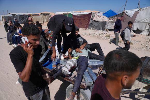 Des Palestiniens transportent un homme blessé par des tirs près d’un centre d’aide humanitaire géré par la Gaza Humanitarian Foundation à Khan Younès, dans le sud de la bande de Gaza, le 29 mai 2025.