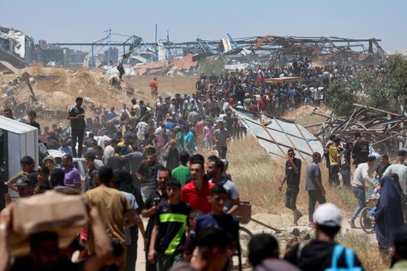 Des Palestiniens venus recevoir des colis d’aide alimentaire de la Gaza Humanitarian Foundation, dans le centre de la bande de Gaza, le 29 mai 2025.