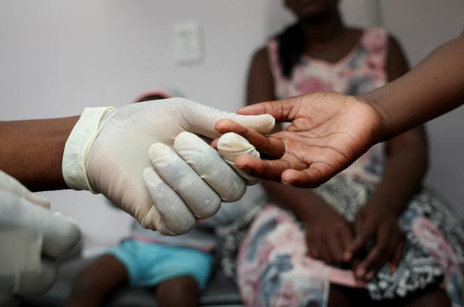 Une infirmière prélève un échantillon de sang sur un enfant pour un test de dépistage du VIH, dans une clinique de Diepsloot, au nord de Johannesburg, en Afrique du Sud, le 12 mars 2025.