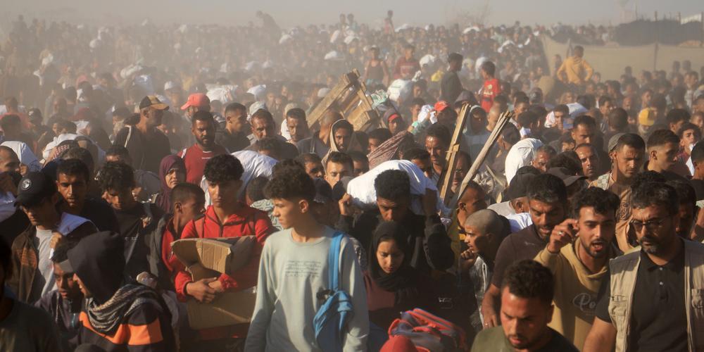 Des Palestiniens portent des cartons et des sacs contenant de la nourriture et des colis d’aide humanitaire livrés par la Gaza Humanitarian Foundation (GHF), à Rafah, dans le sud de la bande de Gaza, le 29 mai 2025. - MARIAM DAGGA / AP