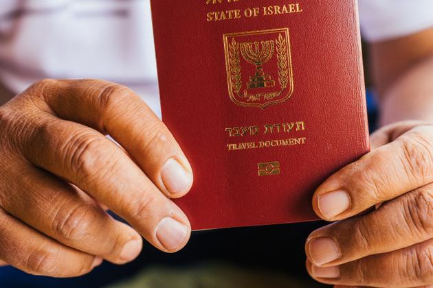 Qassem Sabbagh, journaliste druze, présente son « document de voyage », un laissez-passer délivré par Israël à la place d’un passeport, sur lequel est inscrit « indéfinie » dans la case nationalité, à son domicile dans la ville de Majdal Shams, sur le territoire syrien occupé par Israël dans les hauteurs du Golan, le 8 mai 2025.