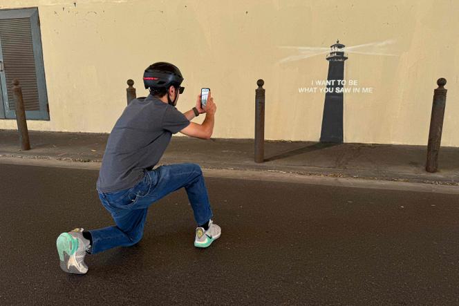 Un piéton prend une photo du phare de Banksy, nouvelle œuvre de l’artiste découverte à Marseille, le 30 mai 2025.