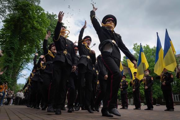 Des cadets diplômés lancent des pièces en l’air pour célébrer leur diplôme, au lycée des cadets de Kiev, le 30 mai 2025.