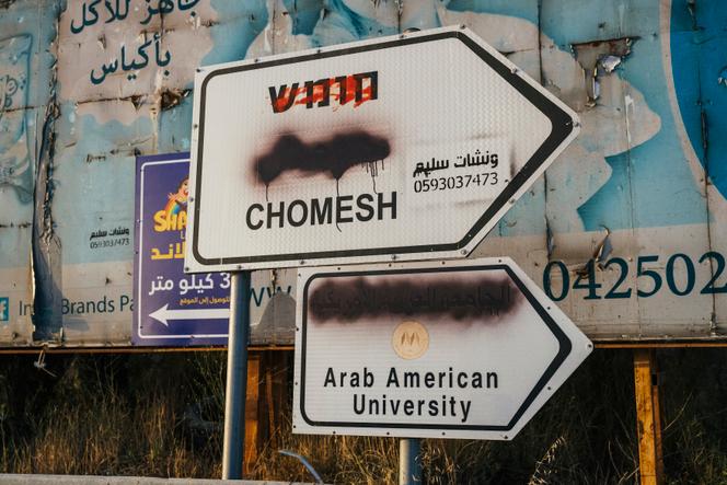 Des traductions arabes sont recouvertes de peinture, souvent par des colons nationalistes, sur des panneaux de signalisation indiquant Chomesh, une colonie israélienne, et  l’Université arabo-américaine, près de la ville de Silat Ad-Dahr, en Cisjordanie occupée, le 25 mai 2025.