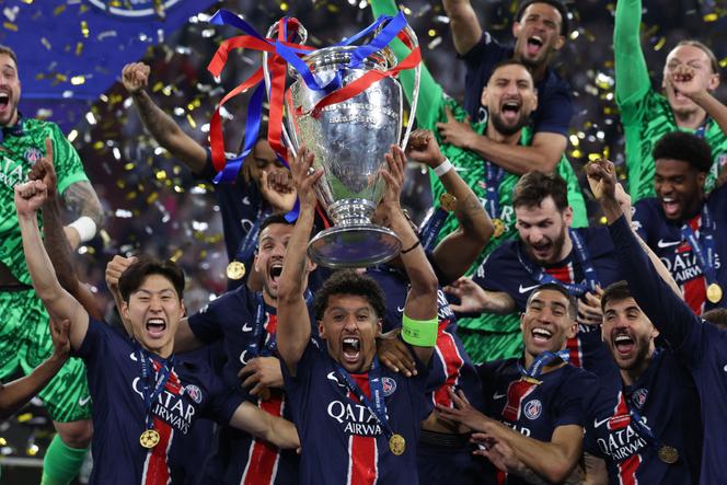 Marquinhos levanta o troféu cercado por seus colegas de equipe após a vitória na final da Liga dos Campeões contra o Inter Milan (5-0) em Munique, 31 de maio de 2025.