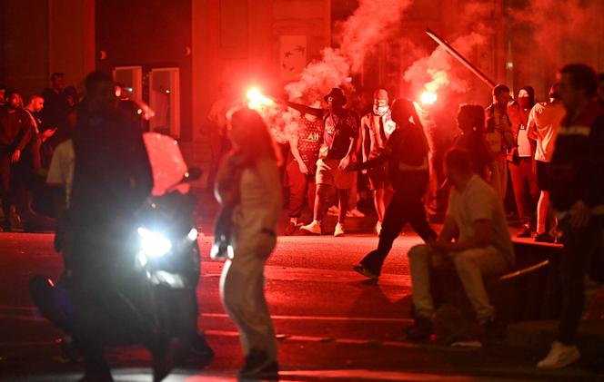 Des supporters du PSG masqués défilent dans une rue de Paris, dans la nuit du 31 mai au 1er juin 2025, après la victoire du Paris Saint-Germain en finale de la Ligue des champions.