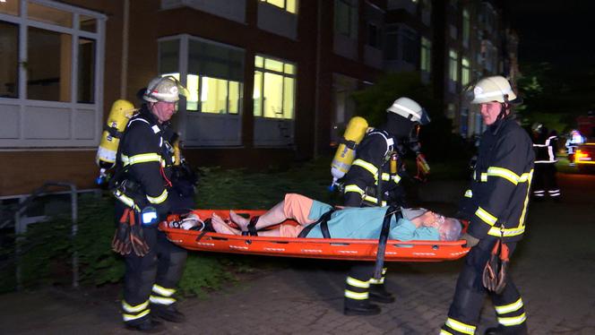 Des pompiers transportent une personne âgée hors de l’hôpital Marienkrankenhaus à Hambourg, dans le nord de l’Allemagne, lors d’un incendie survenu dans la nuit du 31 mai au 1er juin 2025. 