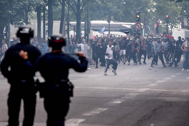 Des policiers affrontent la foule après le défilé du bus de l’équipe du PSG, près de l’avenue des Champs-Elysées à Paris, le 1er juin 2025, un jour après que le PSG a remporté la finale de la Ligue des champions de l’UEFA 2025 contre l’Inter Milan à Munich.