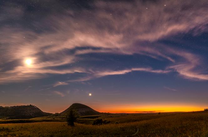 La Lune illumine le ciel crépusculaire qui se charge d’étoiles, mont Lozère en juin 2023.