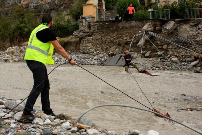 Un ambulancier (au centre) aide un technicien d’Orange à dégager un câble de fibre optique destiné à la connexion Internet, à Tende (Alpes-Maritimes), après le passage de la tempête Alex, le 9 octobre 2020.