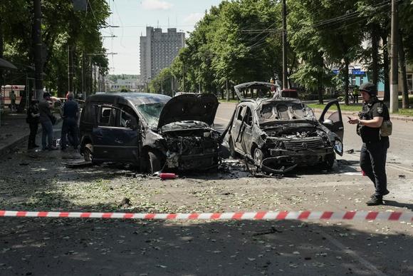 Un policier ukrainien devant les carcasses de voitures, après une frappe de missile russe sur Sumy, dans le nord est de l’Ukraine, le 3 juin 2025.