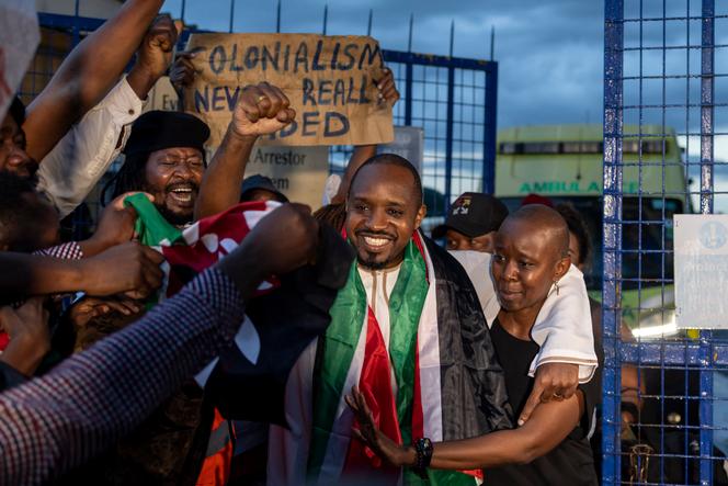Le militant kényan des droits humains, Boniface Mwangi (au centre), à son arrivée à l’aéroport de Nairobi, après sa libération par les autorités tanzaniennes, le 22 mai 2025.