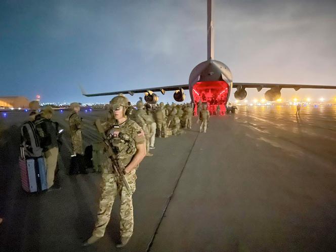 Sur cette image fournie par l’armée américaine, des parachutistes affectés à la 82ᵉ division aéroportée et d’autres soldats se préparent à embarquer dans un avion cargo C-17 à l’aéroport international Hamid Karzai de Kaboul, le 30 août 2021.