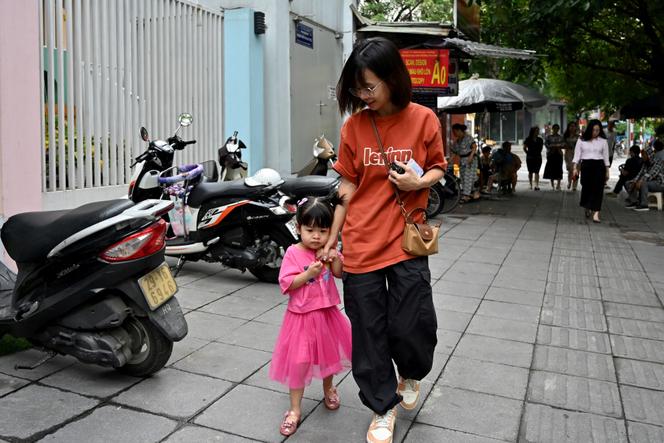 Une mère emmène sa fille à l’école maternelle, à Hanoï, le 4 juin 2025.
