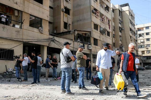 Los residentes evacúan su edificio afectado por un ataque israelí nocturno en el barrio de Hadeth, en los suburbios del sur de Beirut, el 6 de junio de 2025.