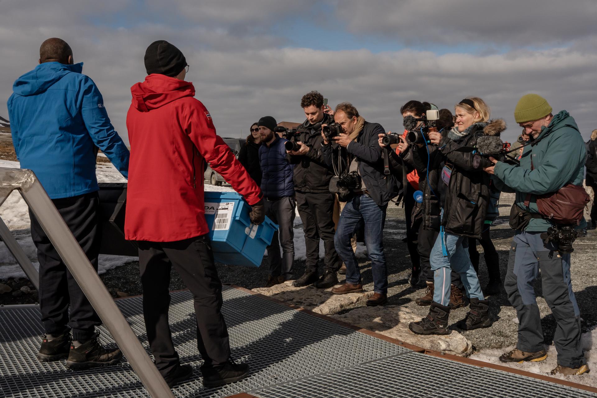 British Foreign Secretary David Lammy and his Norwegian counterpart Espen Barth Eide pose with boxes of seeds in front of members of their communications teams and the media at the entrance of the global agricultural seed vault, near Longyearbyen, in the Svalbard archipelago, May 29, 2025.