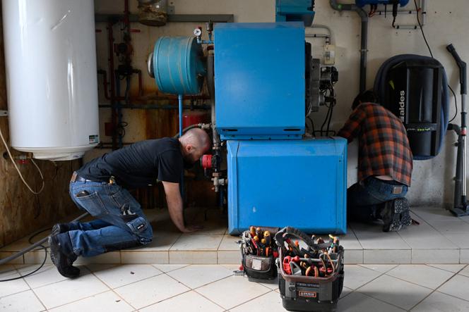 Des ouvriers installent une pompe à chaleur dans une maison privée en Ille-et-Vilaine, en octobre 2023.