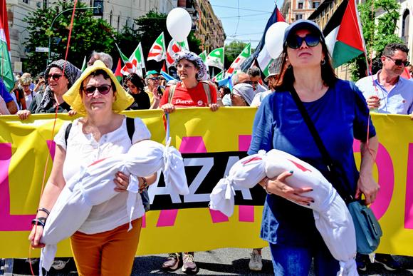Des manifestantes portent des marionnettes couvertes de faux sang, à Rome, samedi 7 juin 2025.