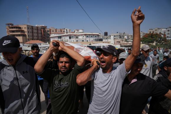 Palestinians carry the body of Ahmed Abu Hilal, who was killed while traveling to an aid center in Gaza, in Khan Younis, southern Gaza Strip, Sunday, June 8, 2025.