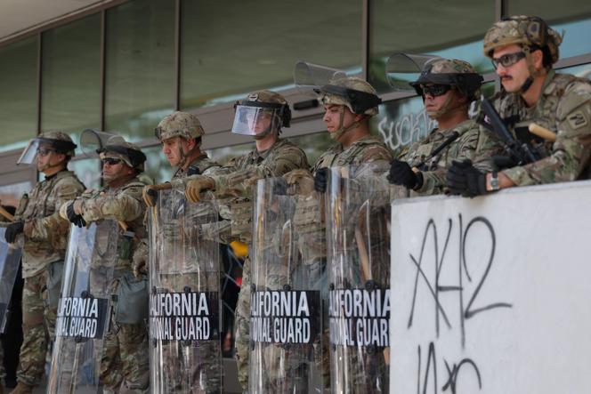Os membros da Guarda Nacional da Califórnia protegem o prédio federal após protestos desencadeados por ataques de imigração, em Los Angeles, em 9 de junho de 2025. 