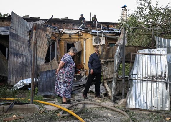 Des habitants à côté d’un bâtiment touché par une frappe de drone russe, à Odessa, en Ukraine, le 10 juin 2025.