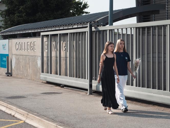 Des jeunes filles viennent déposer des fleurs, devant le collège Françoise-Dolto, à Nogent (Haute-Marne), à la suite de l’agression mortelle d’une surveillante, le 10 juin 2025.