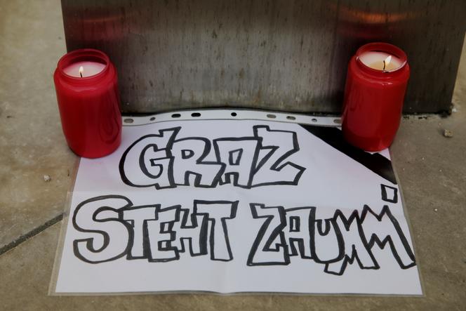 Des bougies allumées à côté d’un morceau de papier avec les mots : « Graz est solidaire », apposé sur la cathédrale, après une fusillade dans une école de Graz, en Autriche, le mardi 10 juin 2025.