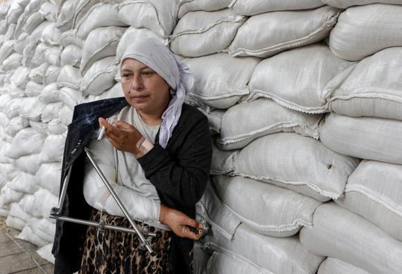 Margaryta Husakova, 37 ans, mère de huit enfants, qui a fui la ville ukrainienne de Bilopilia, devant un centre de réfugiés à Soumy, en Ukraine, le 12 juin 2025.