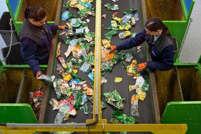 Contrôle manuel de divers emballages broyés et transportés sur un tapis roulant dans un nouveau centre de déchets plastiques, à Epinal, le 28 juin 2024.