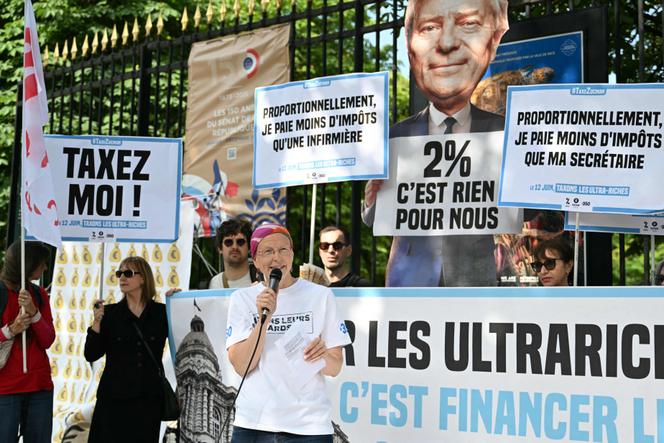 Des membres des associations Attac, Oxfam et 350.org manifestent pour soutenir l’instauration d’une taxe Zucman sur les hauts patrimoines, le 12 juin, devant le Sénat, à Paris.