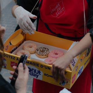 ARTHUR GAU POUR « LE MONDE » A l’occasion du Donut Day, les bénévoles de l’Armée du salut ont distribué des donuts devant le centre commercial Italie 2, à Paris, le 6 juin 2025.